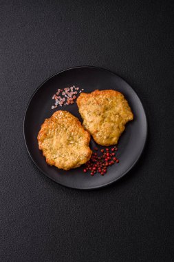 Lezzetli kızarmış domuz ya da koyu beton arka planda tuz ve baharatla ekilmiş tavuk pirzolası.