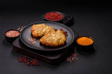 Lezzetli kızarmış domuz ya da koyu beton arka planda tuz ve baharatla ekilmiş tavuk pirzolası.