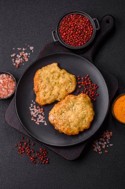 Lezzetli kızarmış domuz ya da koyu beton arka planda tuz ve baharatla ekilmiş tavuk pirzolası.
