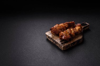 Lezzetli ızgara tavuk, hindi ya da domuz şişi, tuzlu, baharatlı ve otlu, koyu beton bir arka planda.