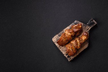 Lezzetli ızgara tavuk, hindi ya da domuz şişi, tuzlu, baharatlı ve otlu, koyu beton bir arka planda.