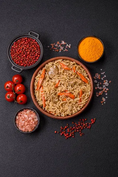 Lezzetli taze pilav, pirinç, havuç, et, soğan, baharat ve böğürtlen ile koyu beton arka planda seramik bir tabakta.