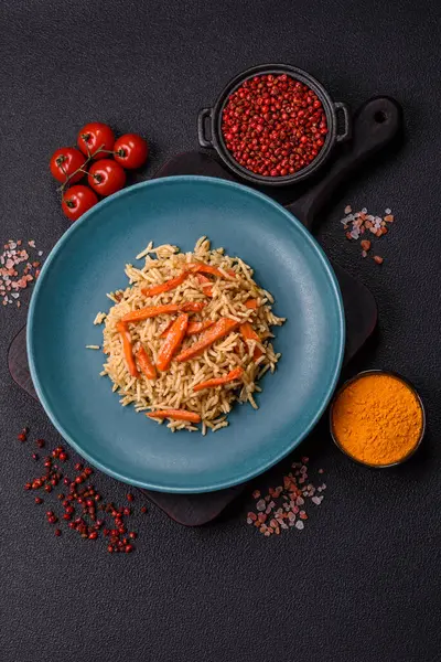 Lezzetli taze pilav, pirinç, havuç, et, soğan, baharat ve böğürtlen ile koyu beton arka planda seramik bir tabakta.