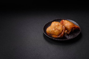 Koyu beton arka planda tuz, baharat ve otlarla kızartılmış tavuk butları.