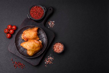 Koyu beton arka planda tuz, baharat ve otlarla kızartılmış tavuk butları.