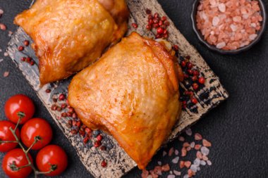 Koyu beton arka planda tuz, baharat ve otlarla kızartılmış tavuk butları.