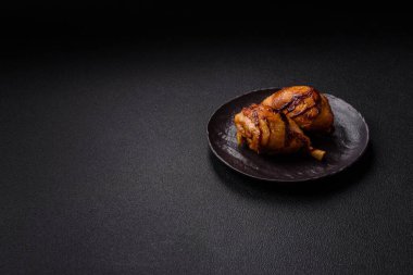 Lezzetli ızgara tavuk bacağı. Baharatlı ve otlu teriyaki soslu. Koyu beton arka planda.