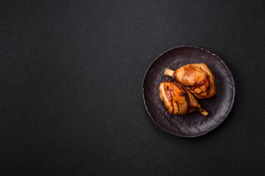 Lezzetli ızgara tavuk bacağı. Baharatlı ve otlu teriyaki soslu. Koyu beton arka planda.