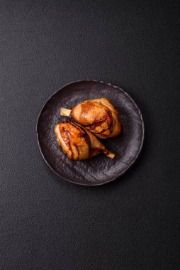 Lezzetli ızgara tavuk bacağı. Baharatlı ve otlu teriyaki soslu. Koyu beton arka planda.