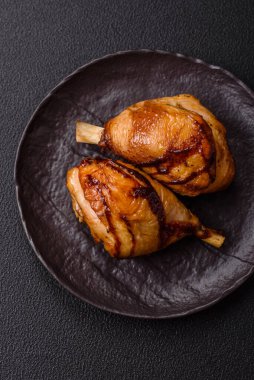 Lezzetli ızgara tavuk bacağı. Baharatlı ve otlu teriyaki soslu. Koyu beton arka planda.