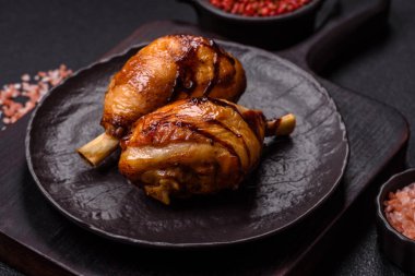 Lezzetli ızgara tavuk bacağı. Baharatlı ve otlu teriyaki soslu. Koyu beton arka planda.