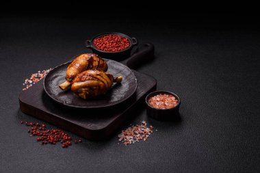 Lezzetli ızgara tavuk bacağı. Baharatlı ve otlu teriyaki soslu. Koyu beton arka planda.