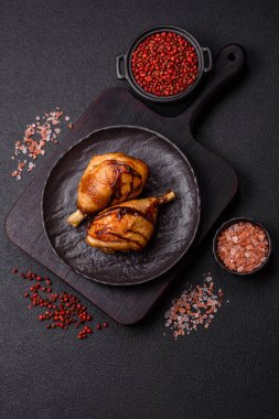 Lezzetli ızgara tavuk bacağı. Baharatlı ve otlu teriyaki soslu. Koyu beton arka planda.