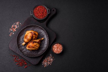 Lezzetli ızgara tavuk bacağı. Baharatlı ve otlu teriyaki soslu. Koyu beton arka planda.