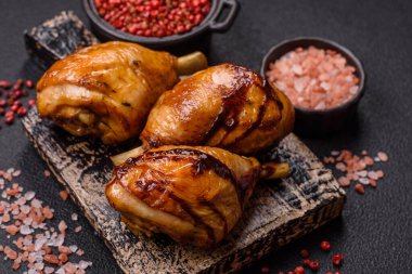 Lezzetli ızgara tavuk bacağı. Baharatlı ve otlu teriyaki soslu. Koyu beton arka planda.