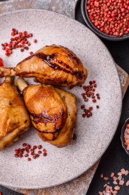 Lezzetli ızgara tavuk bacağı. Baharatlı ve otlu teriyaki soslu. Koyu beton arka planda.