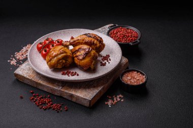 Lezzetli ızgara tavuk bacağı. Baharatlı ve otlu teriyaki soslu. Koyu beton arka planda.
