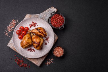 Lezzetli ızgara tavuk bacağı. Baharatlı ve otlu teriyaki soslu. Koyu beton arka planda.