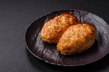 Lezzetli taze kıymalı balık pirzolası. Esmer arka planda baharatlar ve otlarla birlikte.