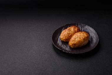 Lezzetli taze kıymalı balık pirzolası. Esmer arka planda baharatlar ve otlarla birlikte.