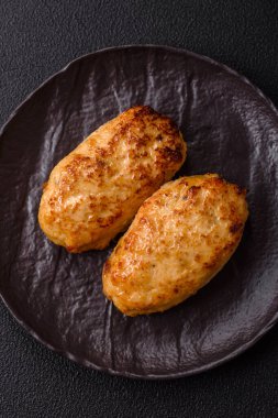 Lezzetli taze kıymalı balık pirzolası. Esmer arka planda baharatlar ve otlarla birlikte.