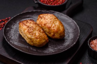 Lezzetli taze kıymalı balık pirzolası. Esmer arka planda baharatlar ve otlarla birlikte.