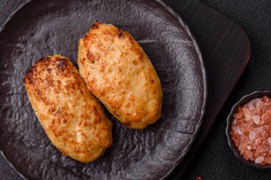 Lezzetli taze kıymalı balık pirzolası. Esmer arka planda baharatlar ve otlarla birlikte.