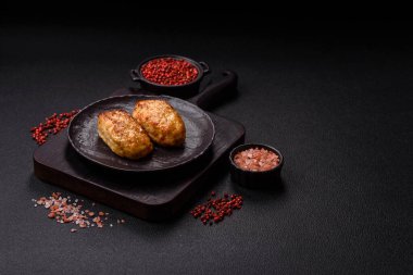 Lezzetli taze kıymalı balık pirzolası. Esmer arka planda baharatlar ve otlarla birlikte.