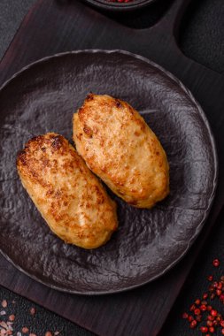 Lezzetli taze kıymalı balık pirzolası. Esmer arka planda baharatlar ve otlarla birlikte.