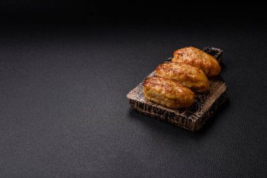 Lezzetli taze kıymalı balık pirzolası. Esmer arka planda baharatlar ve otlarla birlikte.