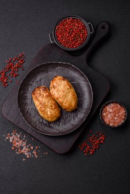 Lezzetli taze kıymalı balık pirzolası. Esmer arka planda baharatlar ve otlarla birlikte.