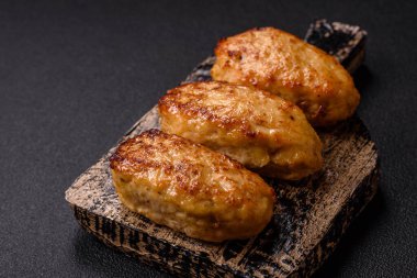 Lezzetli taze kıymalı balık pirzolası. Esmer arka planda baharatlar ve otlarla birlikte.