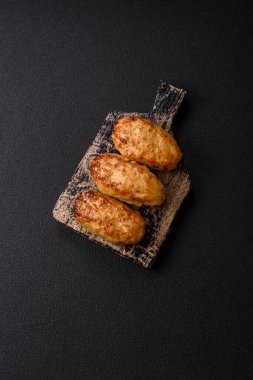 Lezzetli taze kıymalı balık pirzolası. Esmer arka planda baharatlar ve otlarla birlikte.