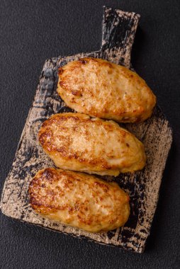 Lezzetli taze kıymalı balık pirzolası. Esmer arka planda baharatlar ve otlarla birlikte.