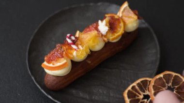 Çikolata dolgulu, krema ve kurutulmuş narenciye ile kaplı nefis bir ekler.