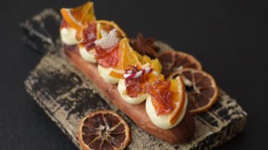 Çikolata dolgulu, krema ve kurutulmuş narenciye ile kaplı nefis bir ekler.