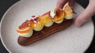 Çikolata dolgulu, krema ve kurutulmuş narenciye ile kaplı nefis bir ekler.