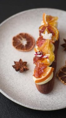 Çikolata dolgulu, krema ve kurutulmuş narenciye ile kaplı nefis bir ekler.