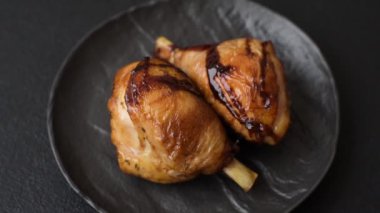 Lezzetli ızgara tavuk bacağı. Baharatlı ve otlu teriyaki soslu. Koyu beton arka planda.