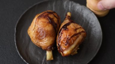 Lezzetli ızgara tavuk bacağı. Baharatlı ve otlu teriyaki soslu. Koyu beton arka planda.