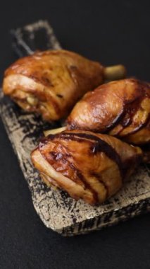 Lezzetli ızgara tavuk bacağı. Baharatlı ve otlu teriyaki soslu. Koyu beton arka planda.