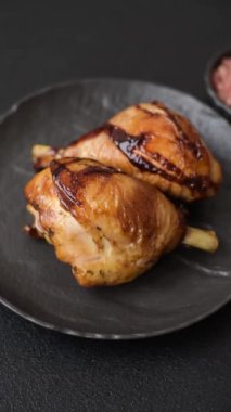 Lezzetli ızgara tavuk bacağı. Baharatlı ve otlu teriyaki soslu. Koyu beton arka planda.