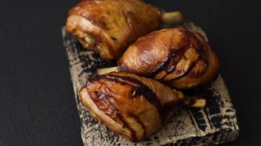 Lezzetli ızgara tavuk bacağı. Baharatlı ve otlu teriyaki soslu. Koyu beton arka planda.