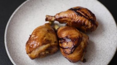 Lezzetli ızgara tavuk bacağı. Baharatlı ve otlu teriyaki soslu. Koyu beton arka planda.