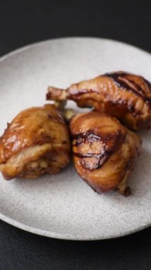 Lezzetli ızgara tavuk bacağı. Baharatlı ve otlu teriyaki soslu. Koyu beton arka planda.