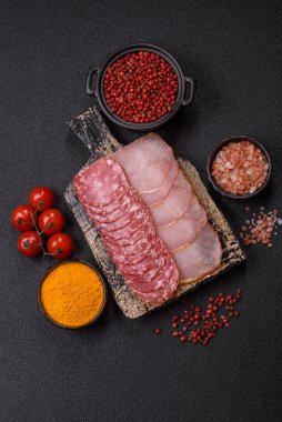 Lezzetli taze füme sosisler. Koyu beton arka planda dilimlerle kesilmiş.