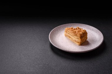 Koyu beton arka planda kremalı Napolyon pastası.
