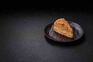 Koyu beton arka planda kremalı Napolyon pastası.