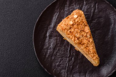 Koyu beton arka planda kremalı Napolyon pastası.