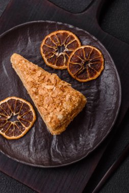 Koyu beton arka planda kremalı Napolyon pastası.